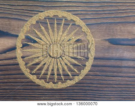 Indian henna powder in the form of Ashoka Chakra on the textured wooden board