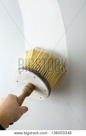 Wall being painted white with brush