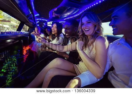 Happy friends chatting in limousine on a night out