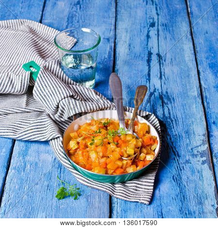 Vegetable stew with sauce on wooden background. Selective focus.