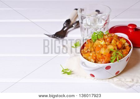 Vegetable stew with sauce on wooden background. Selective focus.