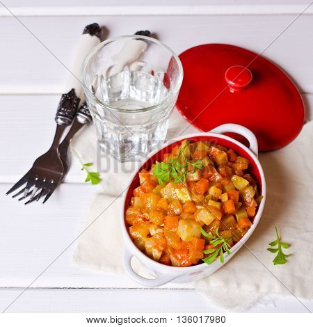 Vegetable stew with sauce on wooden background. Selective focus.