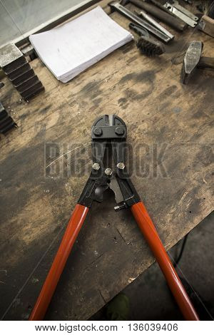 Bolt cutter on wooden old dirty board
