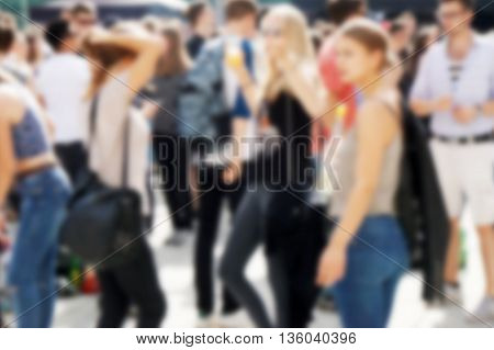 defocused crowd of young people mingling outside