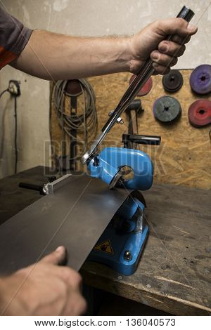 Worker operating old metal sheet press machine