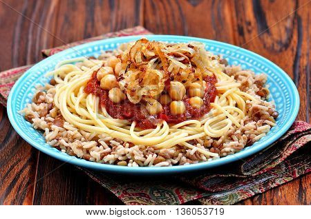 Kushari - Egyptian dish of lentils, rice, pasta, chickpeas with tomato sauce and crispy onions