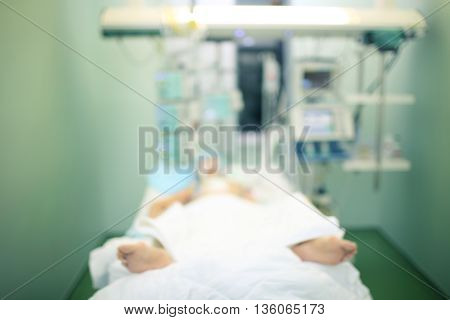 Comatose patient in ICU ward defocused background.