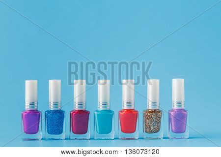 Few colored nail Polish on blue background
