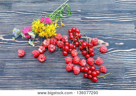 Ripe fresh clusters of red currant and raspberry on the table
