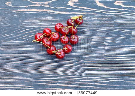Red juicy ripe cherries on a wooden table. Taste of summer
