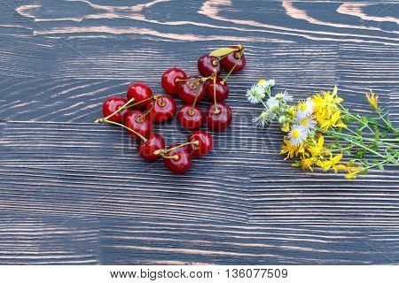 Red juicy ripe cherries on a wooden table. Taste of summer