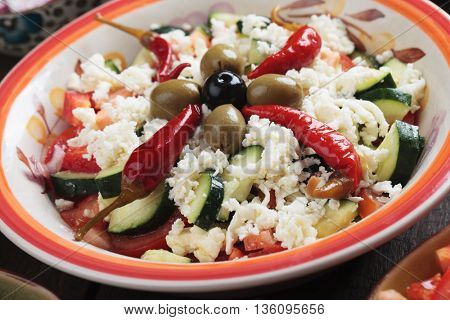 Shopska salad with cheese, hot peppers, olives, cucumber, tomato and onion