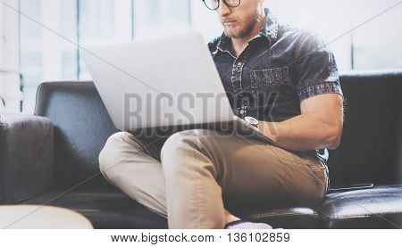 Successful Trade Manager working Laptop modern Interior Design Loft Office.Men work Vintage Sofa, Use contemporary Notebook, Browsing Internet.Blurred Background.Business Startup Idea Process.Horizontal