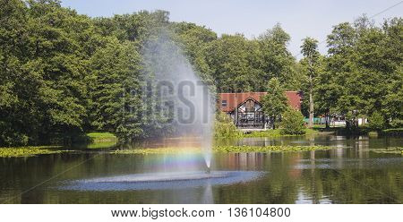 beautiful fountain and rainbow on a lake in the background House plan.