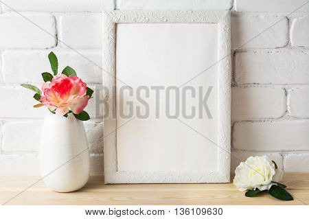 White frame mockup with pink and white roses. Portrait or poster white frame mockup. Empty white frame mockup for design presentation.