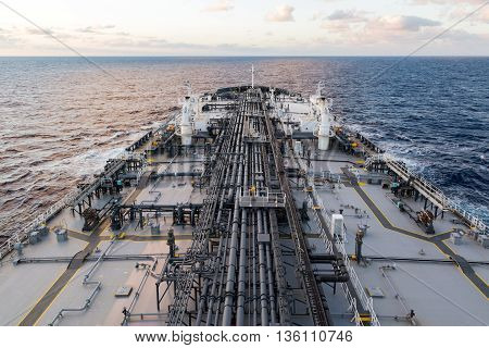 Crude oil tanker forward part of the deck with pipe line in the sea.