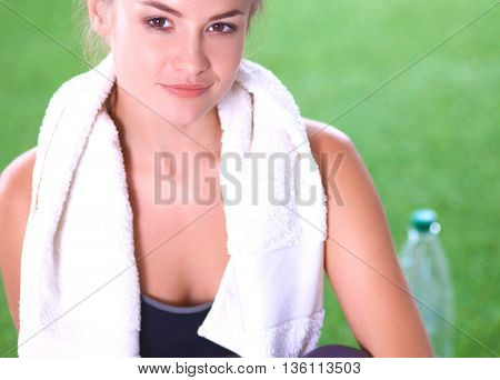 Beautiful young woman relaxing after exerscises on the grass