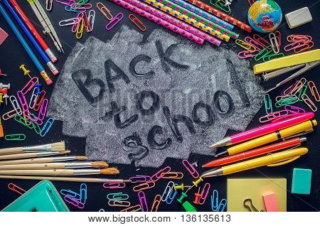 Back to school concept. School supplies on blackboard background. Back to school concept with stationery. Schoolchild and student studies accessories. Top view.