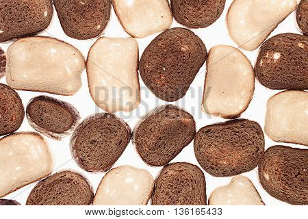 Slices of black rye bread and white bread on a white background. Food background. Pattern.