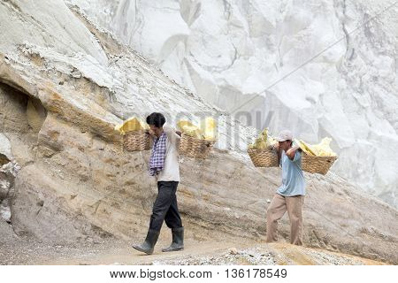 IJEN VOLCANO, INDONESIA - DECEMBER 8 : Unidentified workers carry sulphur inside Ijen crater on December 8, 2011 in Ijen Volcano, Indonesia.