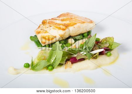 Fried white fish fillet with peas garnish
