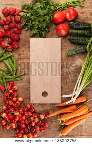 Italian food background, with vine tomatoes, basil, spaghetti, mushrooms, olives, parmesan, olive oil, garlic, peppercorns, rosemary, parsley and thyme. Slate background.
