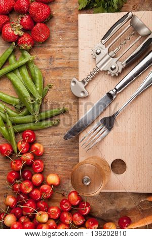 Italian food background, with vine tomatoes, basil, spaghetti, mushrooms, olives, parmesan, olive oil, garlic, peppercorns, rosemary, parsley and thyme. Slate background.