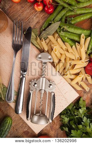 Italian food background, with vine tomatoes, basil, spaghetti, mushrooms, olives, parmesan, olive oil, garlic, peppercorns, rosemary, parsley and thyme. Slate background.
