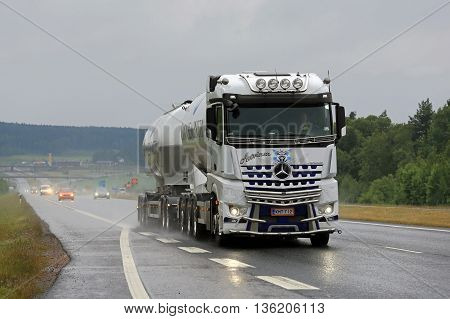SALO, FINLAND - JUNE 17, 2016: White Mercedes-Benz Arocs 3258L tank truck of Kuljetus Auvinen hauls cement along motorway in South of Finland on a rainy day in June.