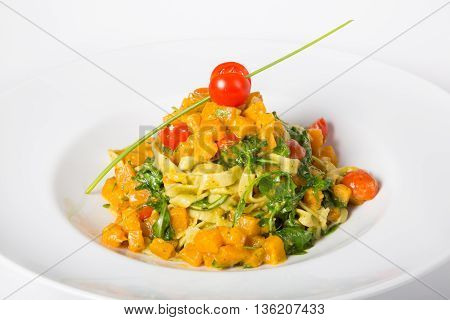 Italian homemade spinach and pumpkin pasta with tomatoes