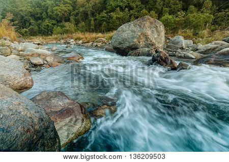 Beautiful Reshi River water flowing on rocks at dawn Sikkim India - a spectacular view tinted image