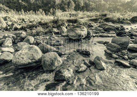 Beautiful Reshi River water flowing on rocks at dawn Sikkim India - a spectacular view tinted image