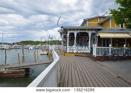 NAANTALI, FINLAND - JUNE 13, 2015: Yachts and boats standing at the historic waterfront of Naantali. On the pier there is a restaurant for tourists, Finland