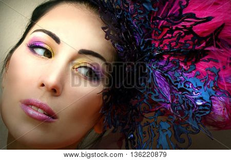 Close-up portrait of beautiful young woman in lace lilac purple hat fascinator with feathers on grey background. Fashion professional violet purple shades make-up. Model shot.