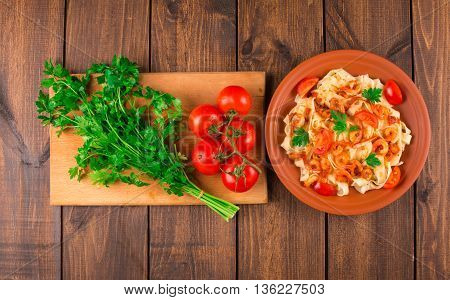 Fettuccine pasta with shrimp tomatoes and herbs. wooden background. Top view