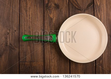 Ceramic Frying Pan on wooden background top view