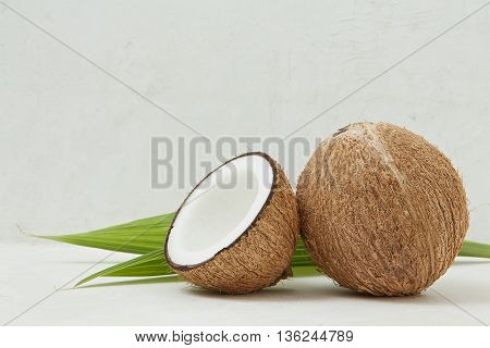 Healthy Coconut, Tropical, Beauty Spa Concept - Close Up Of Coconut Shell Cut Half With Green Leaf O