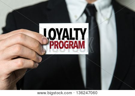 Business man holding a card with the text: Loyalty Program