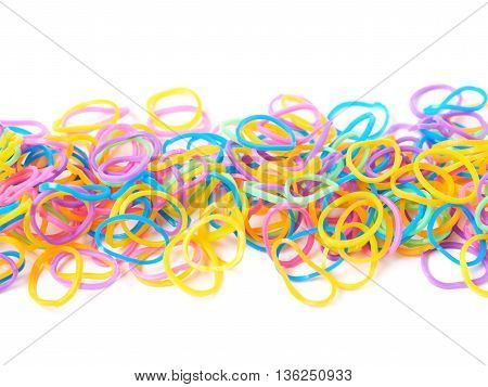 Surface covered with multiple colorful resin loom bands over the white background