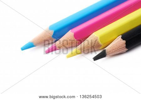 Four cmyk colored drawing pencils composition isolated over the white background, close-up crop
