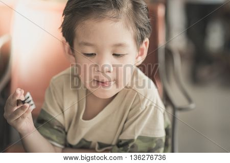 Cute Asian chid eating Spaghetti Carbonara in restaurant vintage fiter