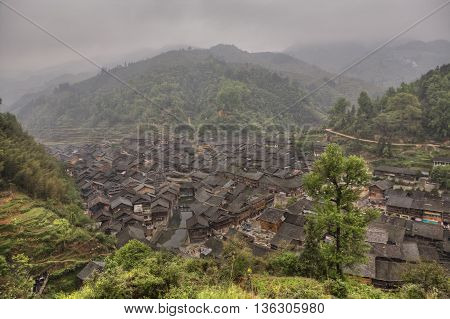 Zhaoxing Dong Village Guizhou Province China - April 7 2010: Panoramic picture of the ethnic minority settlements with wooden houses and tiled roofs in the mountainous area of southwestern China.