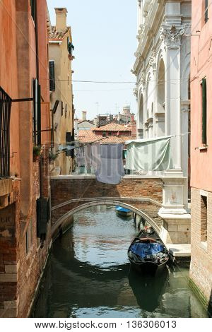 Venetian narrow canal through which a rope strung with drying laundry.