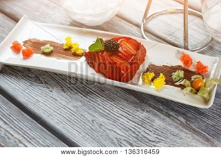 Dessert with strawberry and blackberry. Pieces of bread with berries. Tasty flan served at restaurant. Tasty high-calorie dish.