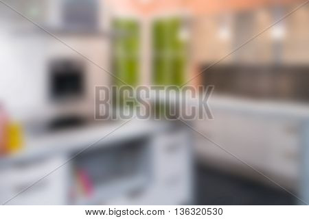Modern kitchen furnishing with desk oven window and lights blurred.