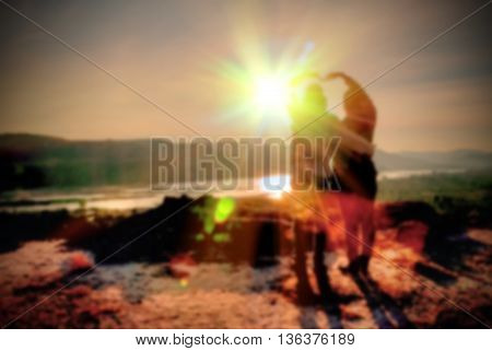Abstract Blurred and soft photo of the lover standing on the hilltop during sunrise.