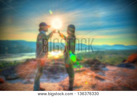 Abstract Blurred and soft photo of the lover standing on the hilltop during sunrise.