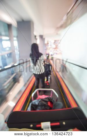 Blur image of people walking down the escalator at airport