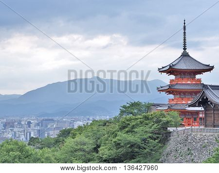 Red Pagoda with city view at Kiyomizu or Kiyomizu-dera temple in Kyoto, Japan. The temple is part of the Historic Monuments of Ancient Kyoto UNESCO World Heritage site.