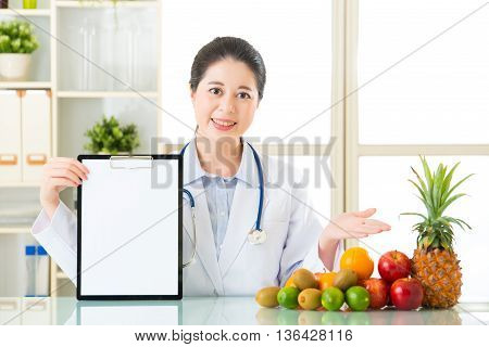 Doctor Nutritionist With Fruits And Holding Blank Clipboard